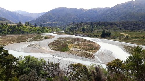 Scenic view of river by mountains