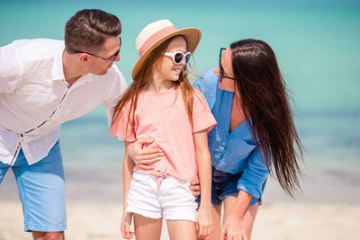 Young woman wearing sunglasses standing at beach