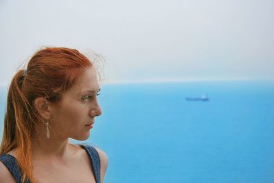 Close-up of young woman against sea