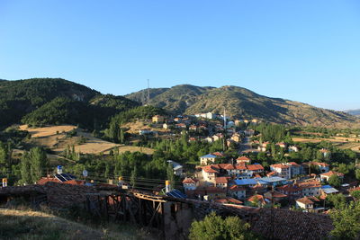 High angle view of houses and mountains against clear blue sky