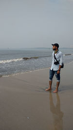 Young photographer standing on the beach