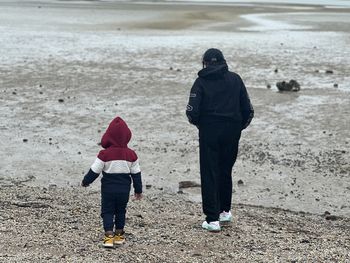 Rear view of woman walking at beach