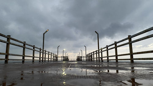 Pier on bridge against sky during rainy season