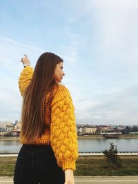 Woman with long hair standing by river