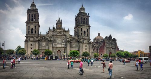 Tourists in front of church against sky