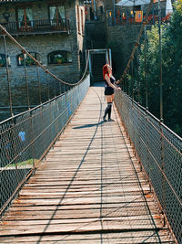 Rear view of woman on footbridge