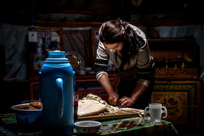 Woman preparing food on table in kitchen