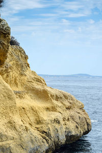 Rock formations by sea against sky