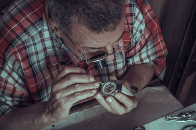 Old watch man fixing watch