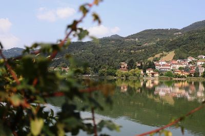 Scenic view of lake by buildings against sky