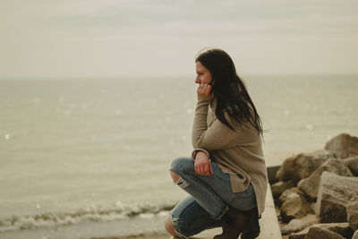 Side view of young woman standing at beach