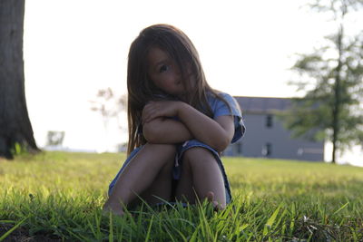 Portrait of cute girl sitting on grass