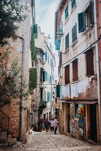 People walking on street amidst buildings in city