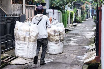 Rear view of the man who sells traditional crackers walking in a residential alley