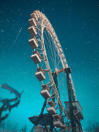 Low angle view of ferris wheel against blue sky