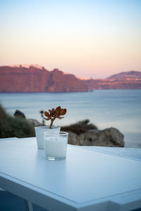 Candle and plant decoration on a white tableat sunset on caldera. portrait format