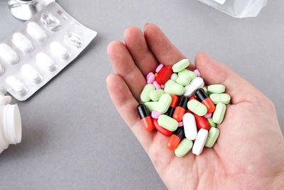 Cropped hand holding colorful medicines