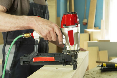 Stapling of wooden parts with a red pneumatic stapler. furniture manufacture.