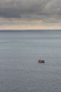 Sailboat sailing on sea against sky