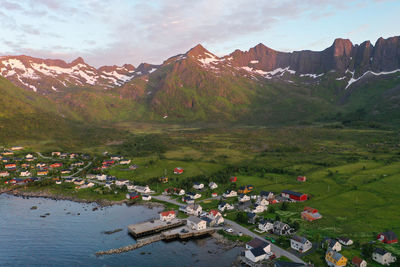 Aerial view of mountains, ocean and a small village during sunset in senja island, norway