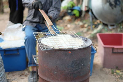 Low section of man preparing food on barbecue grill