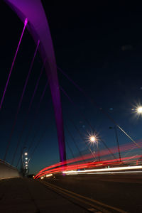 Light trails on road against sky at night