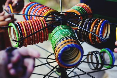 Close-up of colorful bangles on hooks at market