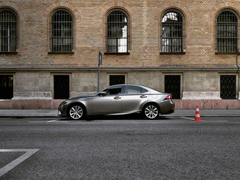 Digital composite image of car on road by building