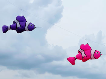Low angle view of toys hanging against sky