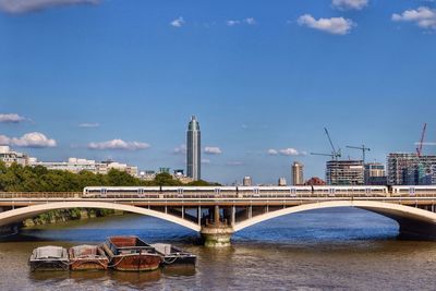 Bridge over river against cloudy sky