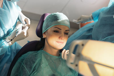 Midsection of dentists treating patient in hospital