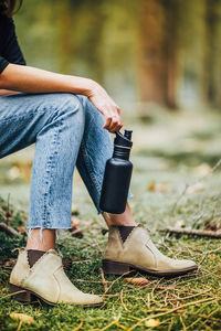 Low section of woman sitting outdoors