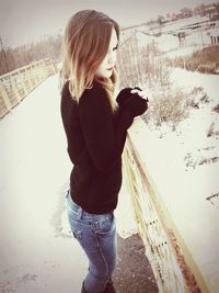 Young woman standing on snow covered landscape