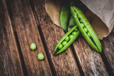 High angle view of pea by paper bag on table