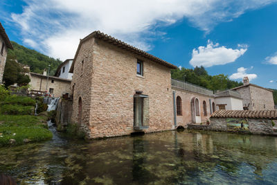 Building by lake against sky