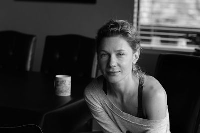 Portrait of woman sitting on seat at home