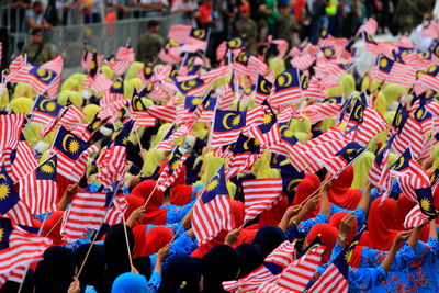 Group of people holding malaysian flag during parade