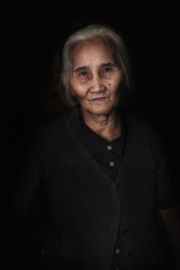 Portrait of a smiling young woman over black background