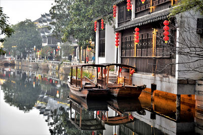 Boats in canal by buildings in city