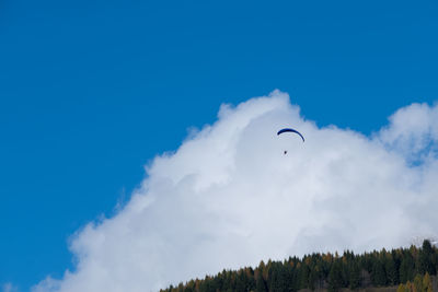 Low angle view of person paragliding against sky