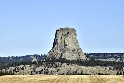 Built structure on landscape against clear blue sky