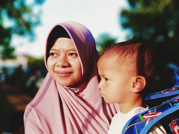 Close-up of woman carrying son