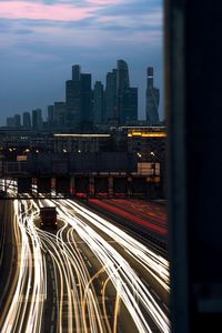 High angle view of light trails on road amidst buildings in city