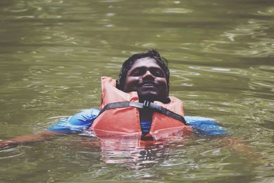 Man wearing lifeguard swimming in lake