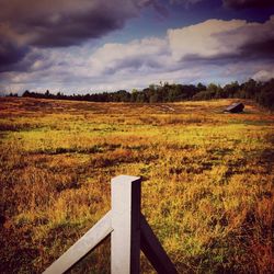 Scenic view of grassy field against cloudy sky