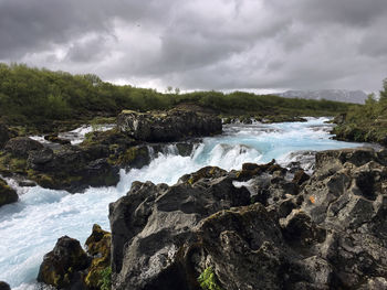 Scenic view of rocks on beach against sky