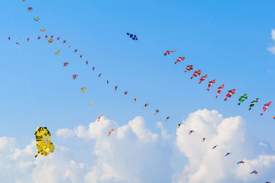 Low angle view of kites flying against sky