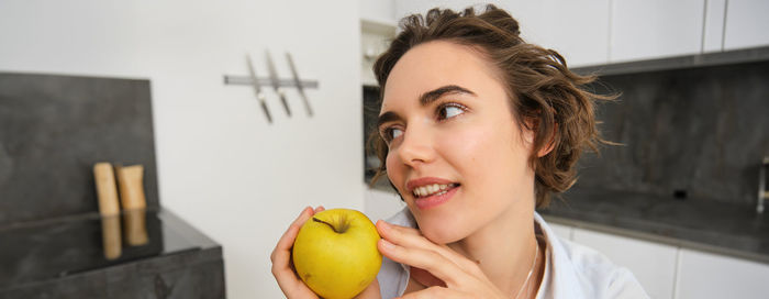 Portrait of young woman holding fruit