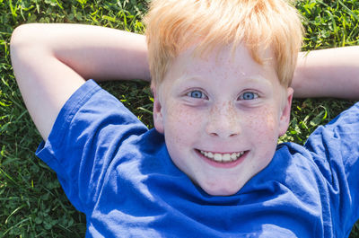 Portrait of smiling boy lying on grass