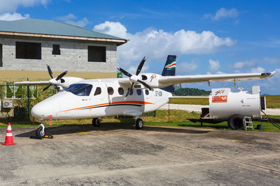 Airplane on airport runway against sky